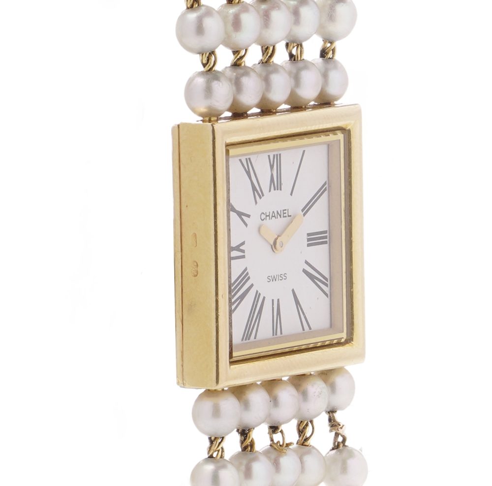 Chanel gold wristwatch with pearl bracelet.