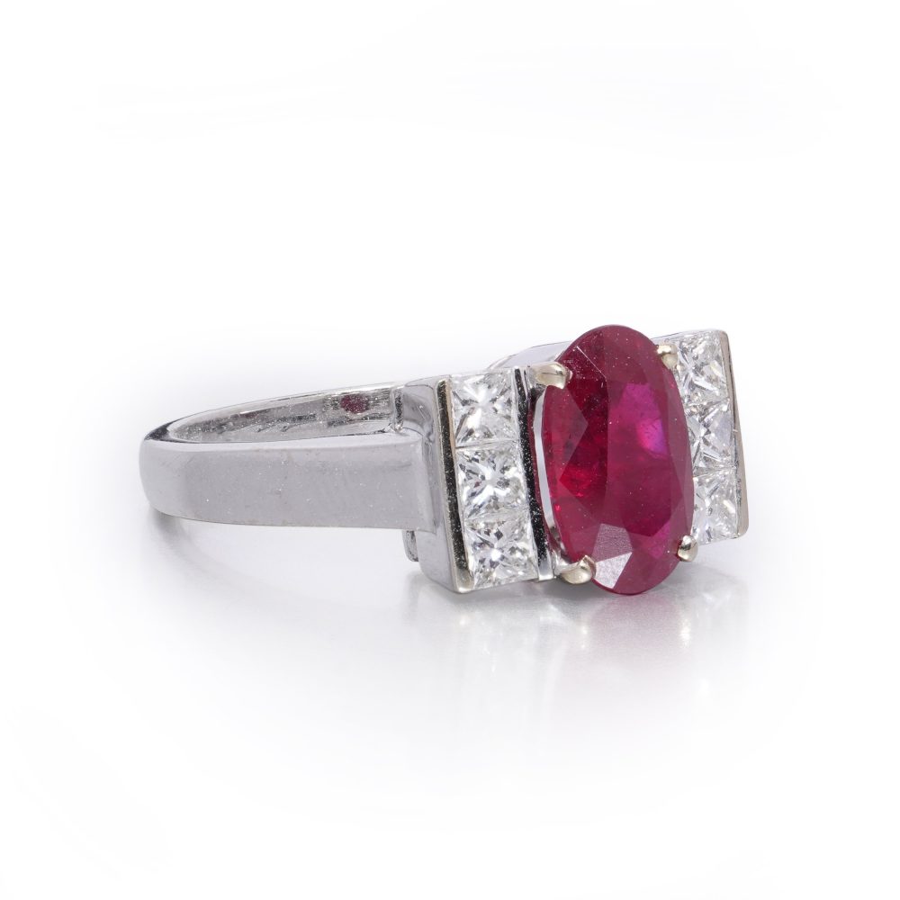 2.15ct Oval Ruby and Princess Cut Diamond Engagement Ring, vibrant oval mixed-cut natural ruby flanked by a row of vertically set square princess-cut diamonds to each side in 18ct white gold