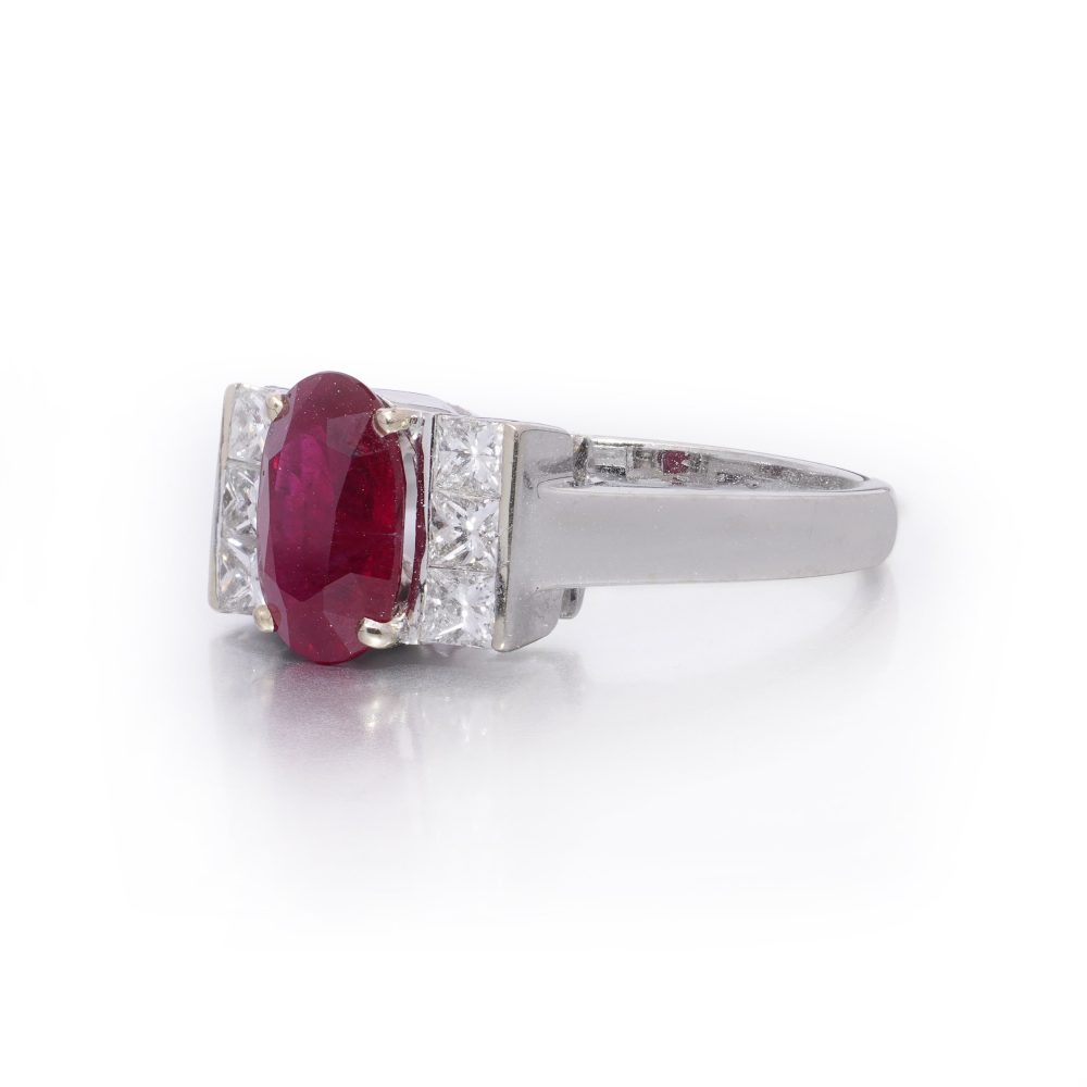 2.15ct Oval Ruby and Princess Cut Diamond Engagement Ring, vibrant oval mixed-cut natural ruby flanked by a row of vertically set square princess-cut diamonds to each side in 18ct white gold