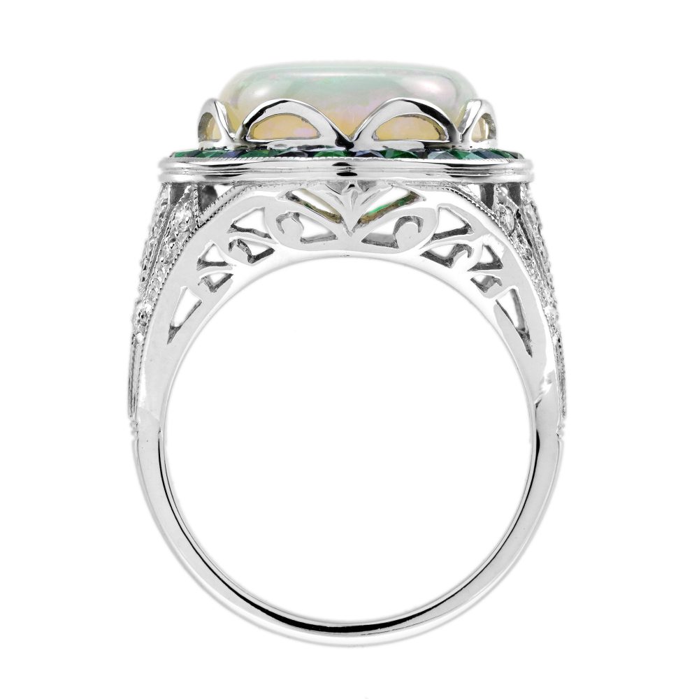8.73ct Opal Emerald Sapphire Cluster Cocktail Ring, central luminous opal encircled by vivid French-cut emeralds alternated with blue sapphires in 18ct white gold with diamond shoulders