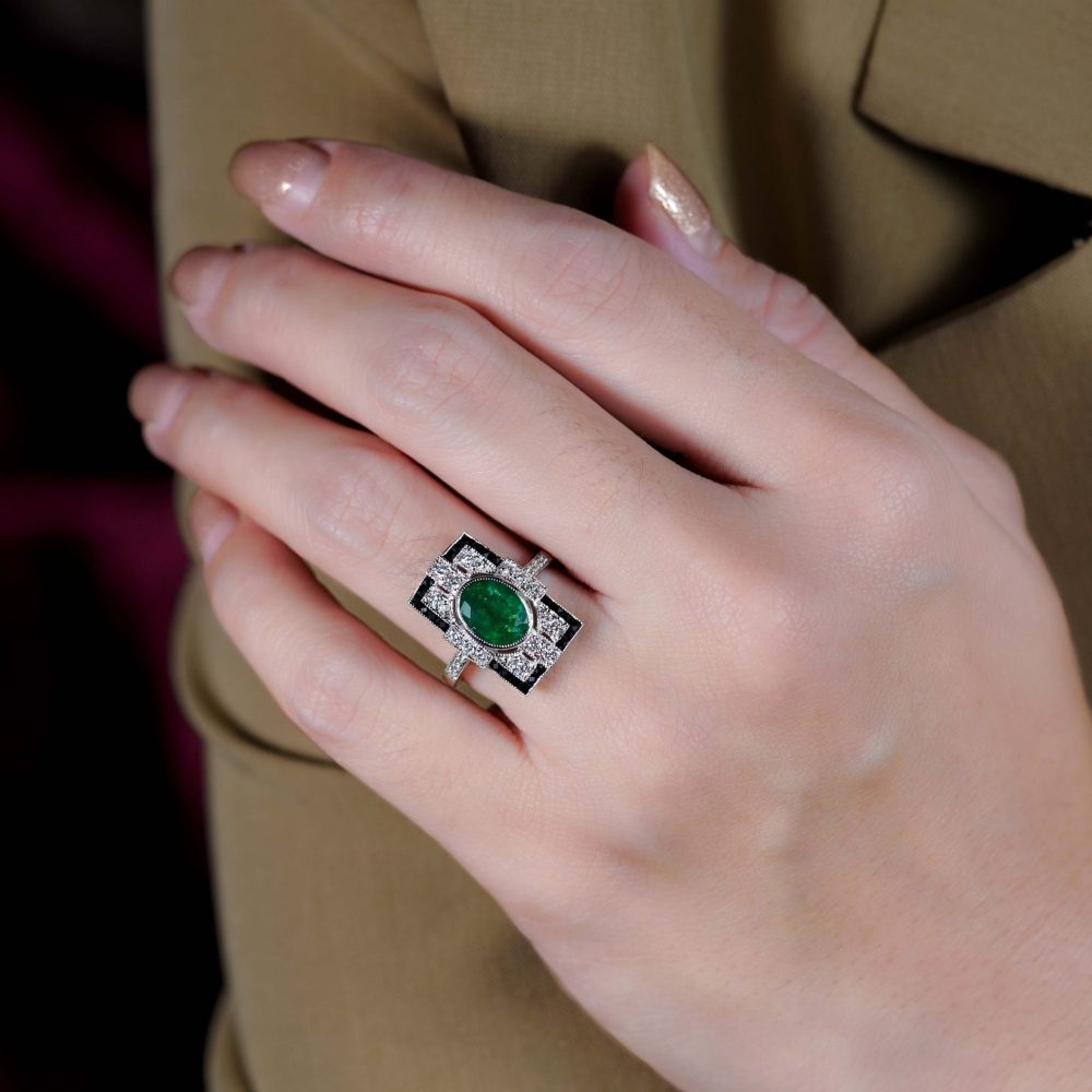 1.80ct. Emerald Diamond and Black Onyx Cluster Plaque Ring, 1.80ct oval vivid green emerald surrounded by sparkling diamonds framed with a sleek black onyx border in 18ct white gold