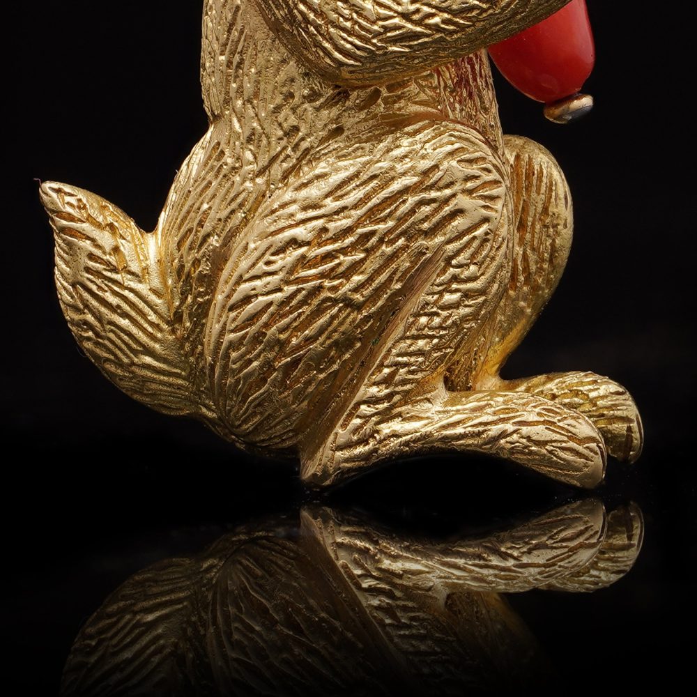 Gold bunny brooch with coral carrot and ruby eye.