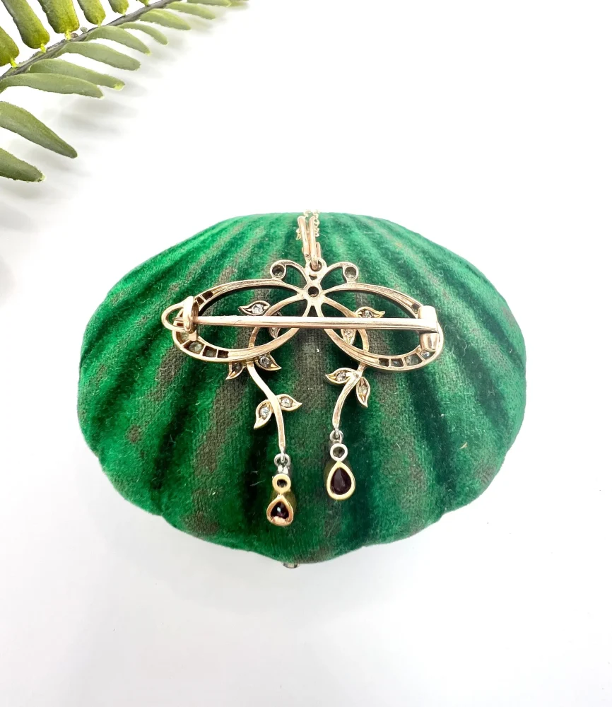 Belle Epoque Edwardian Antique Diamond Bow Pendant Brooch with Ruby Drops with enchanting vine motifs in platinum and yellow gold, Circa 1910