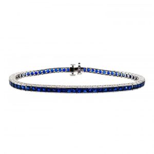 Modern 7.36ct Sapphire Line Bracelet in Platinum, 7.36 carats of square-cut blue sapphires channel set in individually hinged links with foliate engraved openwork sides
