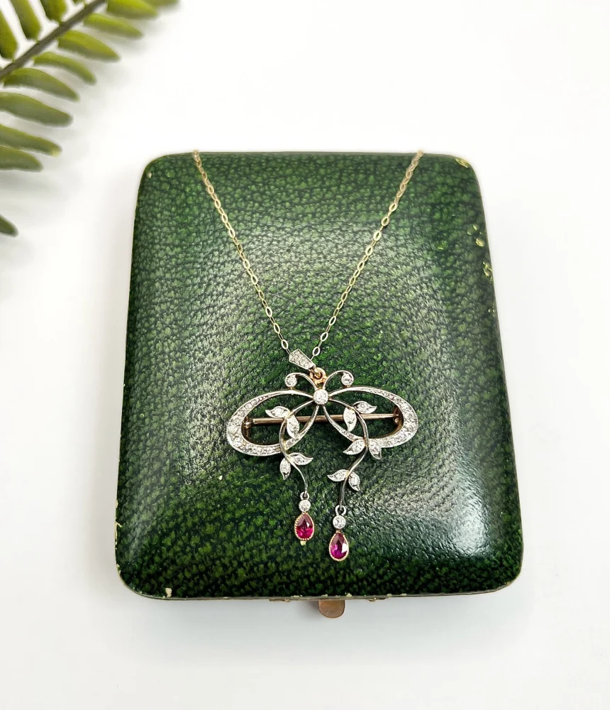 Belle Epoque Edwardian Antique Diamond Bow Pendant Brooch with Ruby Drops with enchanting vine motifs in platinum and yellow gold, Circa 1910