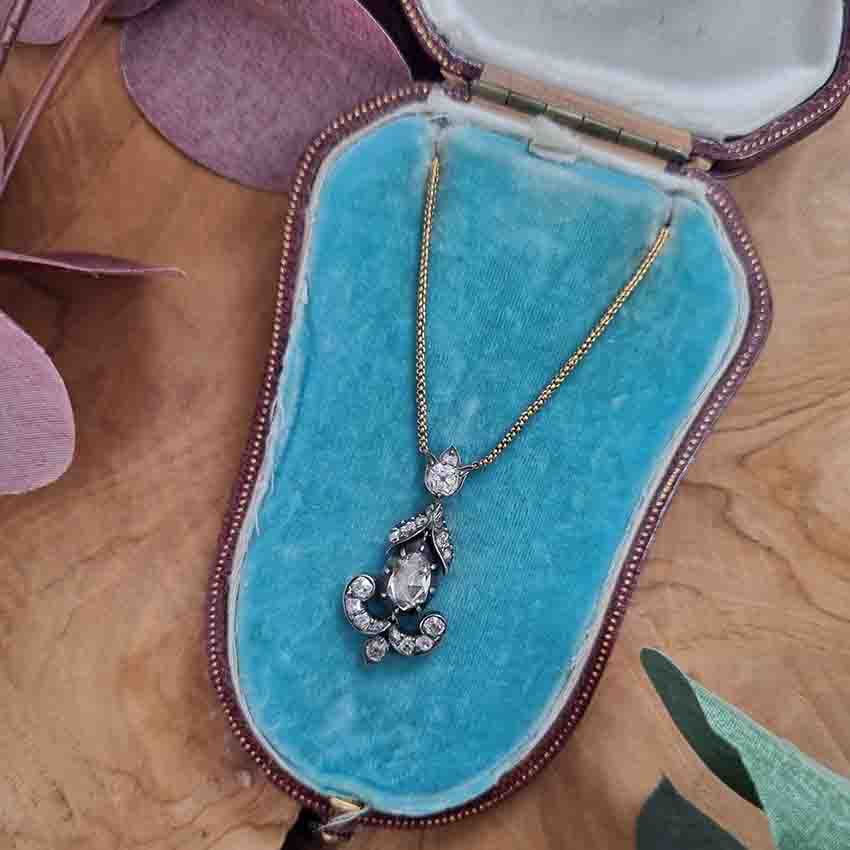 Antique 1ct Rose Cut Diamond Pendant, 1.60 carat total, closed-back 1ct rose-cut diamond surrounded by 0.60 carats of old mine-cut diamonds in floral, leaf and scroll design in silver upon gold