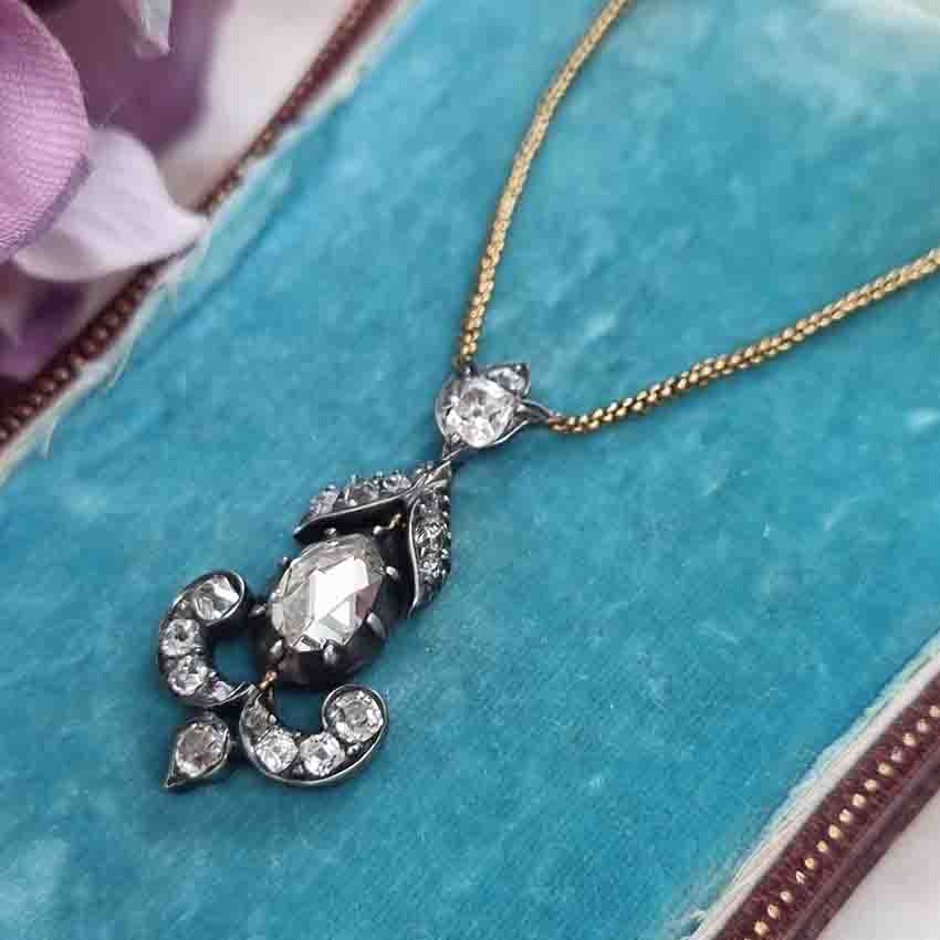Antique 1ct Rose Cut Diamond Pendant, 1.60 carat total, closed-back 1ct rose-cut diamond surrounded by 0.60 carats of old mine-cut diamonds in floral, leaf and scroll design in silver upon gold