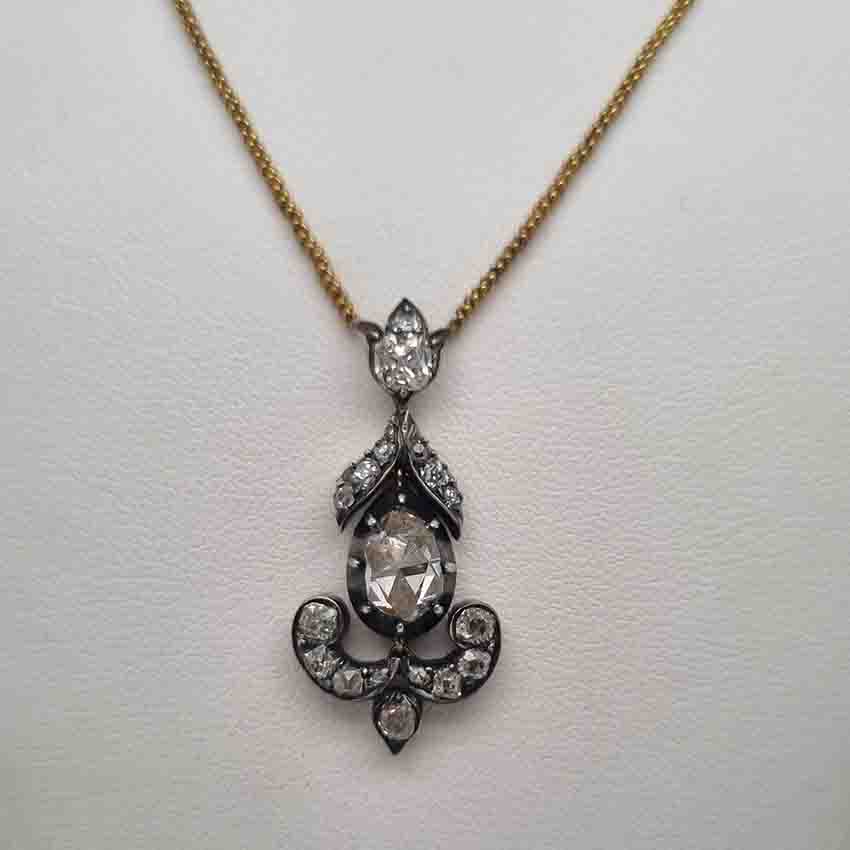 Antique 1ct Rose Cut Diamond Pendant, 1.60 carat total, closed-back 1ct rose-cut diamond surrounded by 0.60 carats of old mine-cut diamonds in floral, leaf and scroll design in silver upon gold