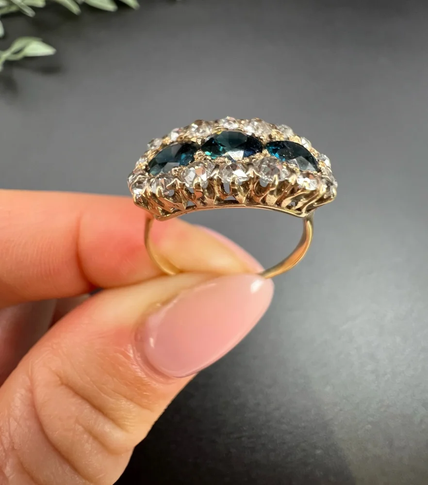 Edwardian Antique Sapphire and Diamond Triple Cluster Ring, trilogy sapphires framed by halos of sparkling old-cut diamonds in 18ct rose gold. Circa 1900