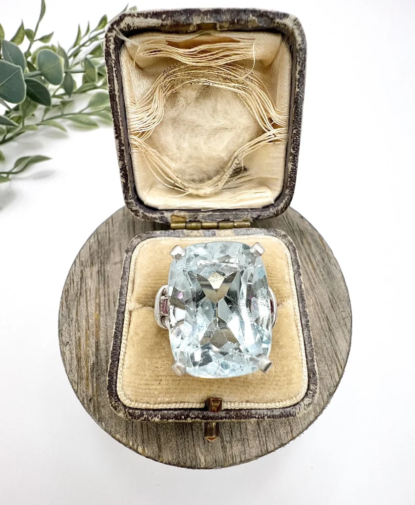 Vintage Cushion Cut Aquamarine Cocktail Ring with Ruby Shoulders in Platinum, 12ct cushion-cut aquamarine on reeded platinum band set with calibre red rubies. Circa 1960s