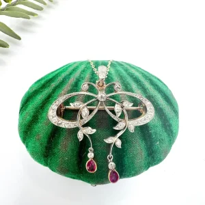 Belle Epoque Edwardian Antique Diamond Bow Pendant Brooch with Ruby Drops with enchanting vine motifs in platinum and yellow gold, Circa 1910