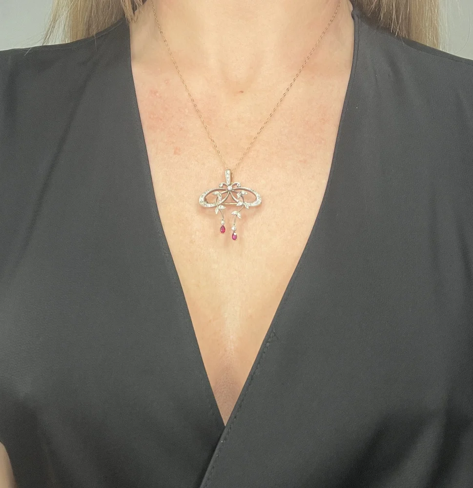 Belle Epoque Edwardian Antique Diamond Bow Pendant Brooch with Ruby Drops with enchanting vine motifs in platinum and yellow gold, Circa 1910
