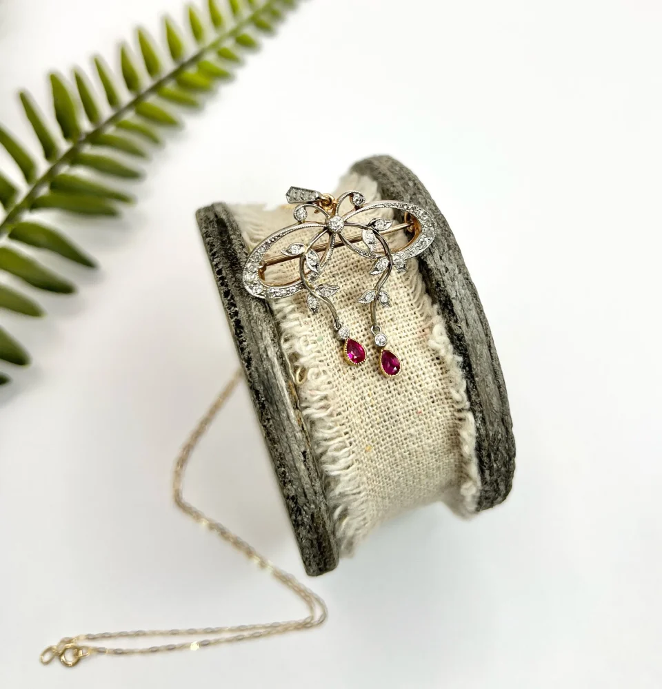 Belle Epoque Edwardian Antique Diamond Bow Pendant Brooch with Ruby Drops with enchanting vine motifs in platinum and yellow gold, Circa 1910