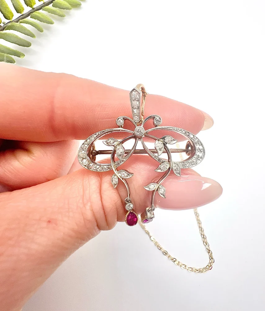 Belle Epoque Edwardian Antique Diamond Bow Pendant Brooch with Ruby Drops with enchanting vine motifs in platinum and yellow gold, Circa 1910