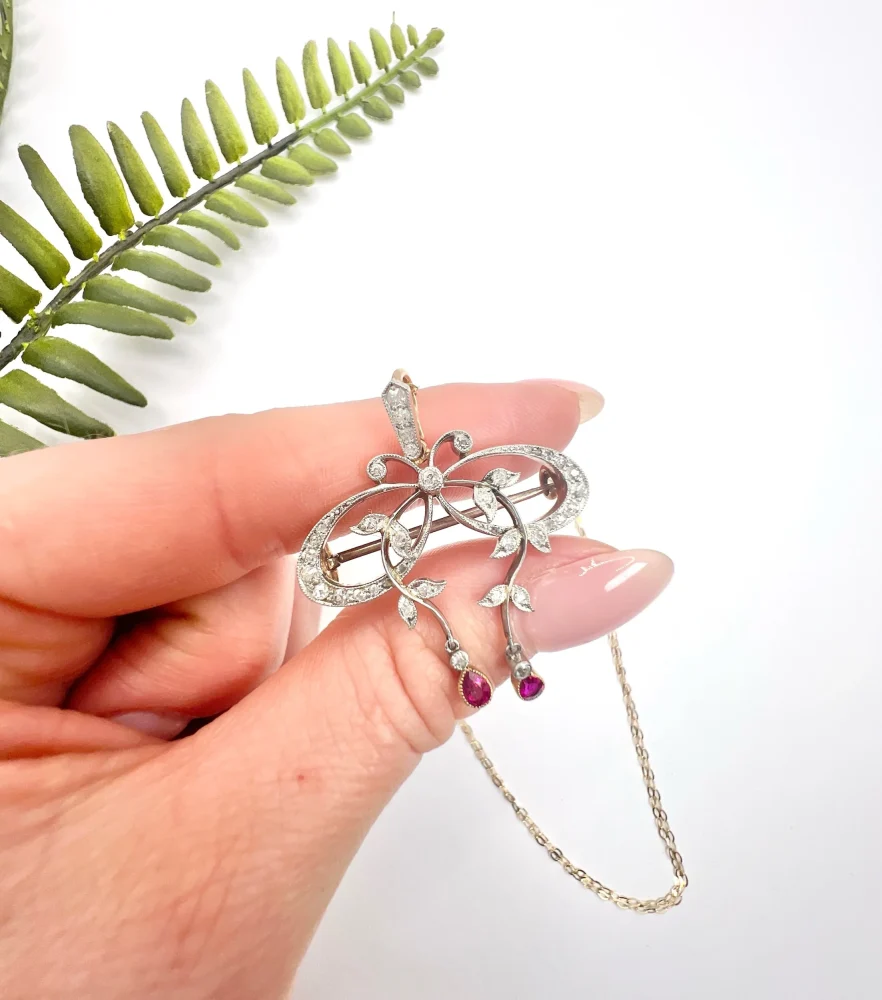 Belle Epoque Edwardian Antique Diamond Bow Pendant Brooch with Ruby Drops with enchanting vine motifs in platinum and yellow gold, Circa 1910