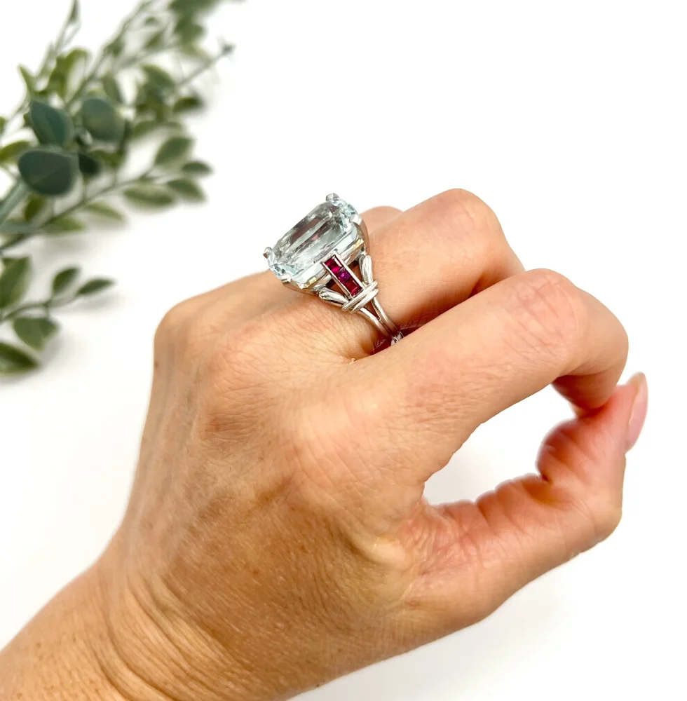 Vintage Cushion Cut Aquamarine Cocktail Ring with Ruby Shoulders in Platinum, 12ct cushion-cut aquamarine on reeded platinum band set with calibre red rubies. Circa 1960s
