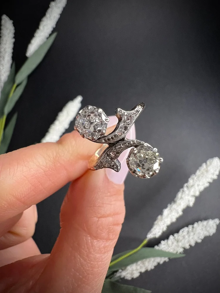Belle Epoque Antique Diamond Toi et Moi Two Stone Ring, Claw set with cushion-cut diamonds with 'vine' design diamond shoulders in 18ct gold. Circa 1900