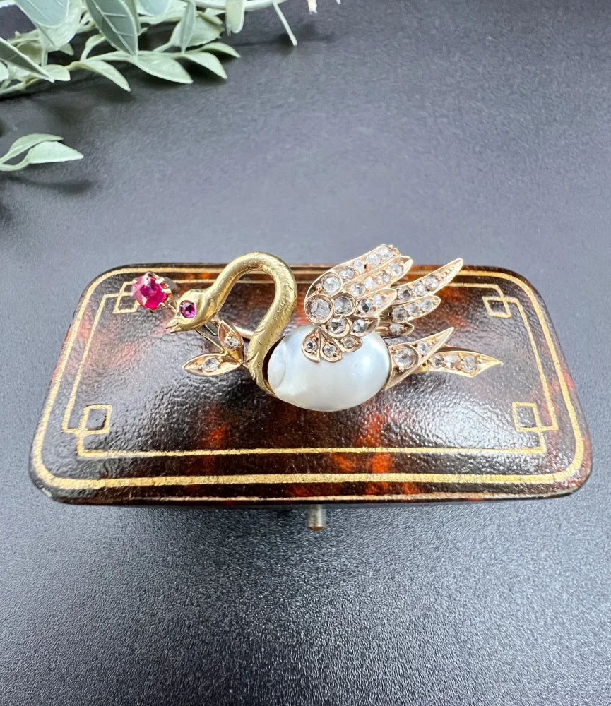 Antique swan brooch in gold with gemstones.