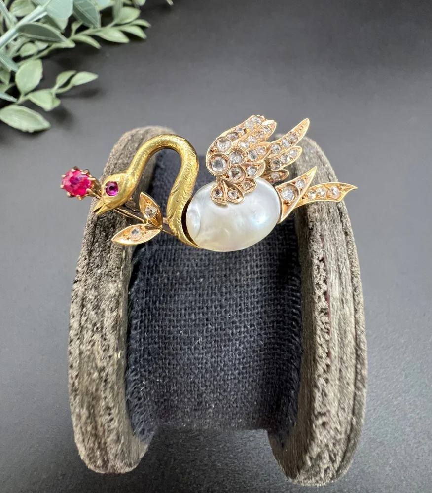 Antique swan brooch in gold with gemstones.