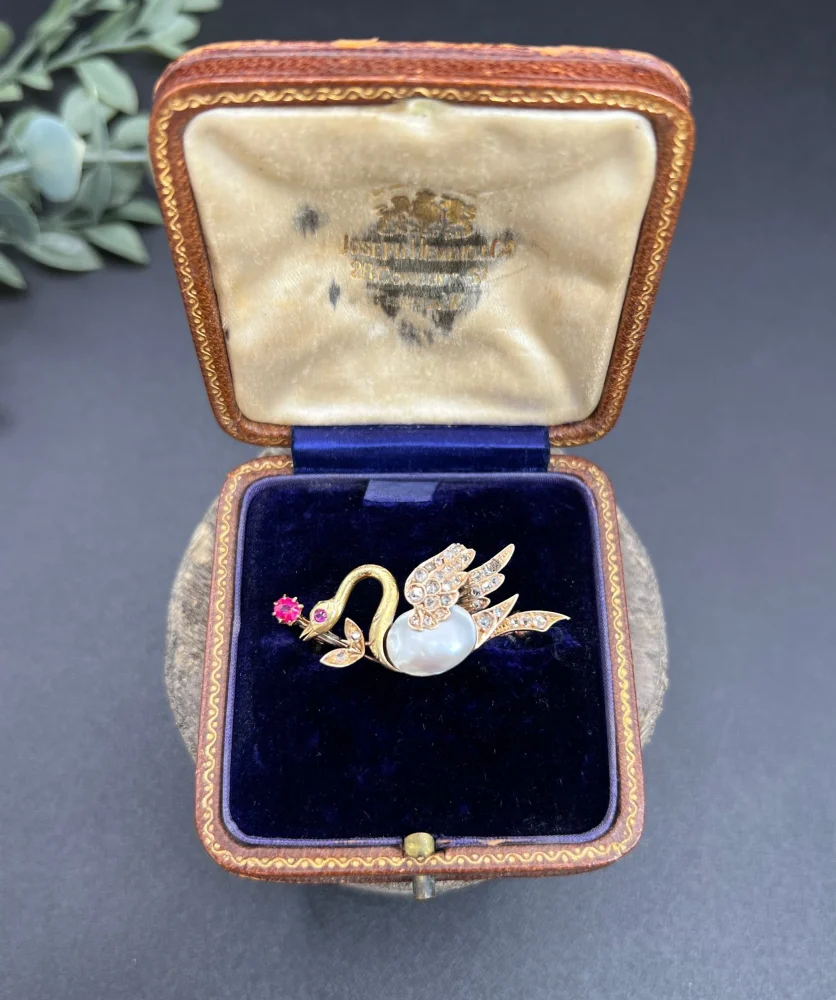 Antique swan brooch in gold with gemstones.