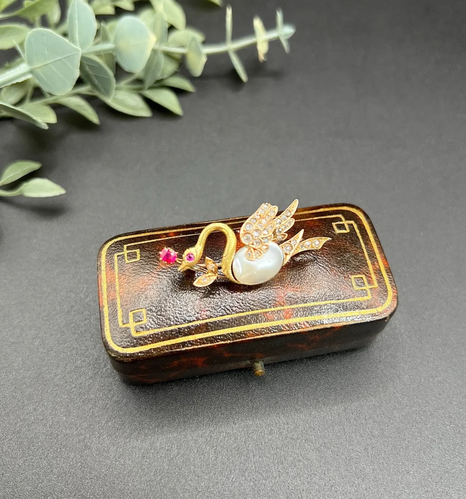 Antique swan brooch in gold with gemstones.