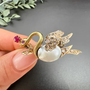 Antique swan brooch in gold with gemstones.