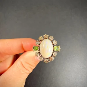 Victorian Antique Opal Diamond and Demantoid Garnet Cluster Ring in 18ct Gold, magnificent opal surrounded by diamonds accented with demantoid garnets in tulip settings. Late 19th century Circa 1880