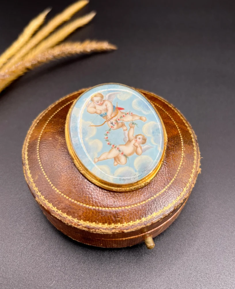 Antique cupid brooch in gold with mother-of-pearl back.