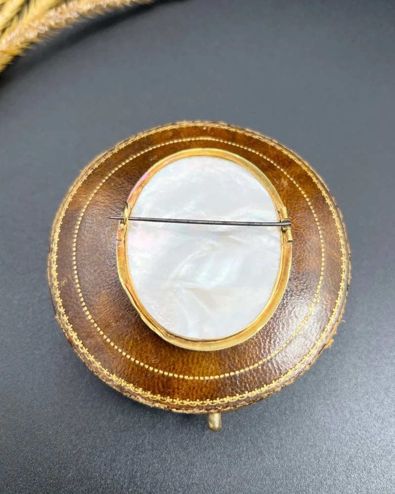 Antique cupid brooch in gold with mother-of-pearl back.