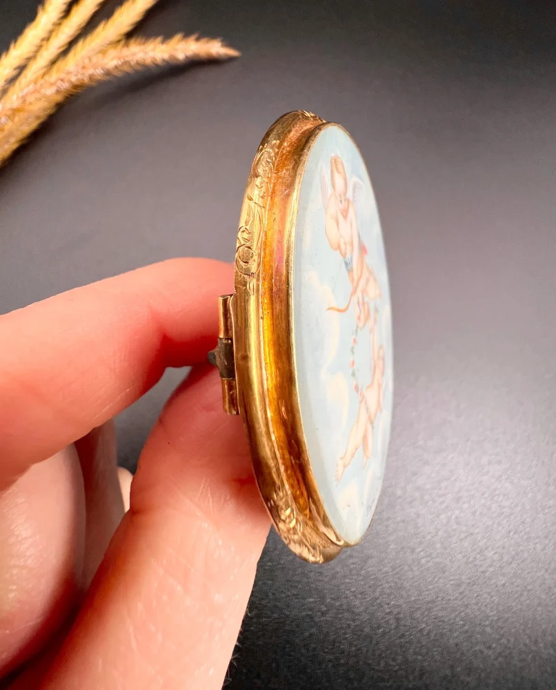 Antique cupid brooch in gold with mother-of-pearl back.