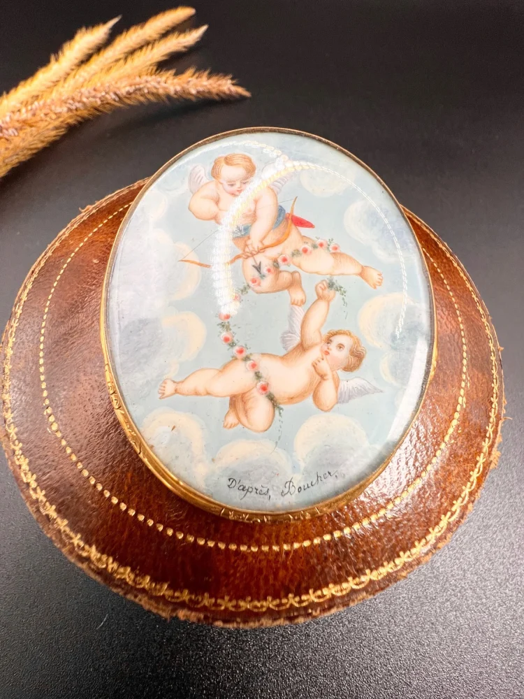 Antique cupid brooch in gold with mother-of-pearl back.