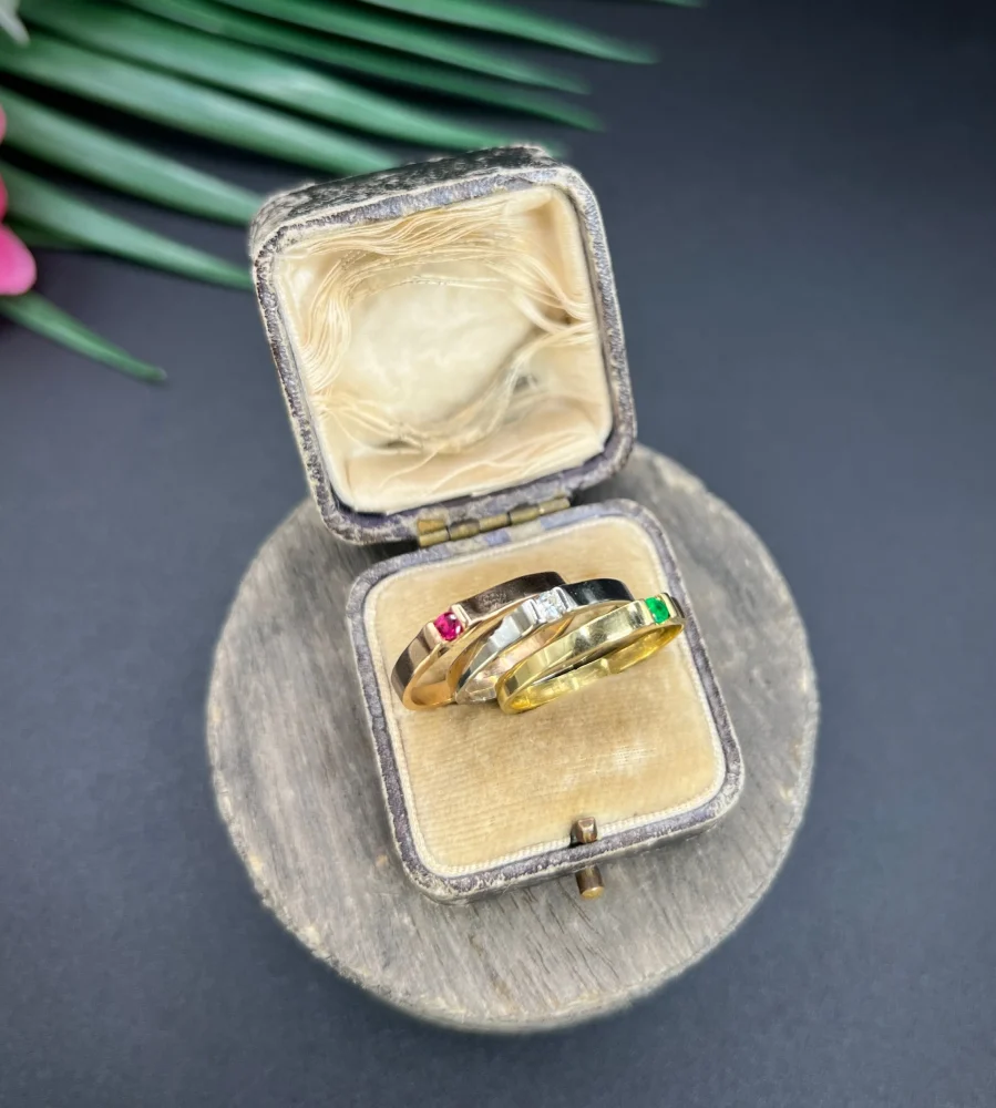 Gold stacking ring with emerald diamond and ruby.