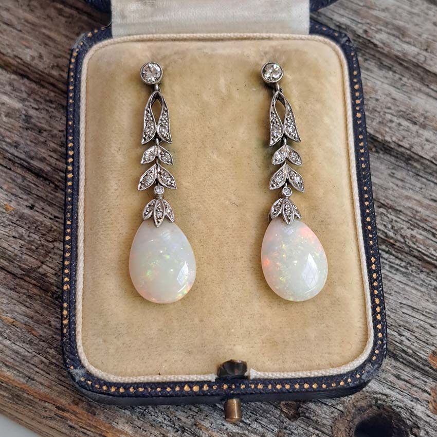 Edwardian Antique Opal and Diamond Drop Earrings, Diamond tops suspend floral diamond leaf designs with trefoil diamond caps holding pear drop opals