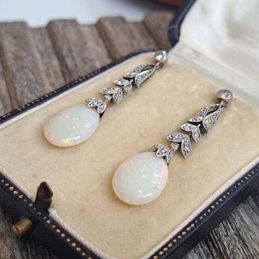 Edwardian Antique Opal and Diamond Drop Earrings, Diamond tops suspend floral diamond leaf designs with trefoil diamond caps holding pear drop opals