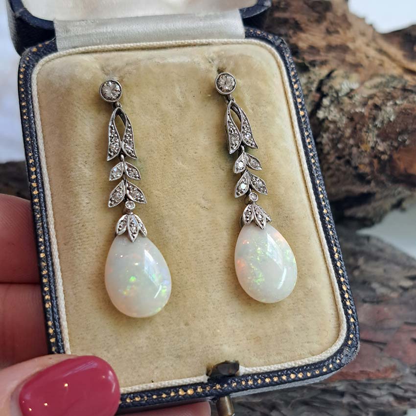 Edwardian Antique Opal and Diamond Drop Earrings, Diamond tops suspend floral diamond leaf designs with trefoil diamond caps holding pear drop opals