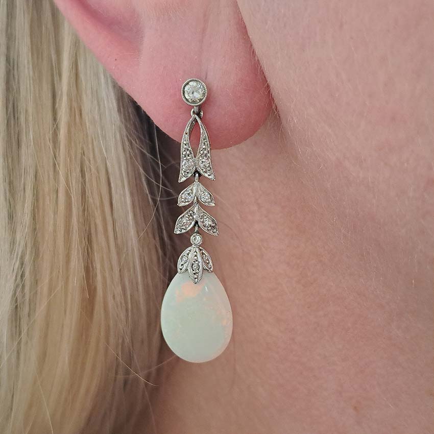 Edwardian Antique Opal and Diamond Drop Earrings, Diamond tops suspend floral diamond leaf designs with trefoil diamond caps holding pear drop opals