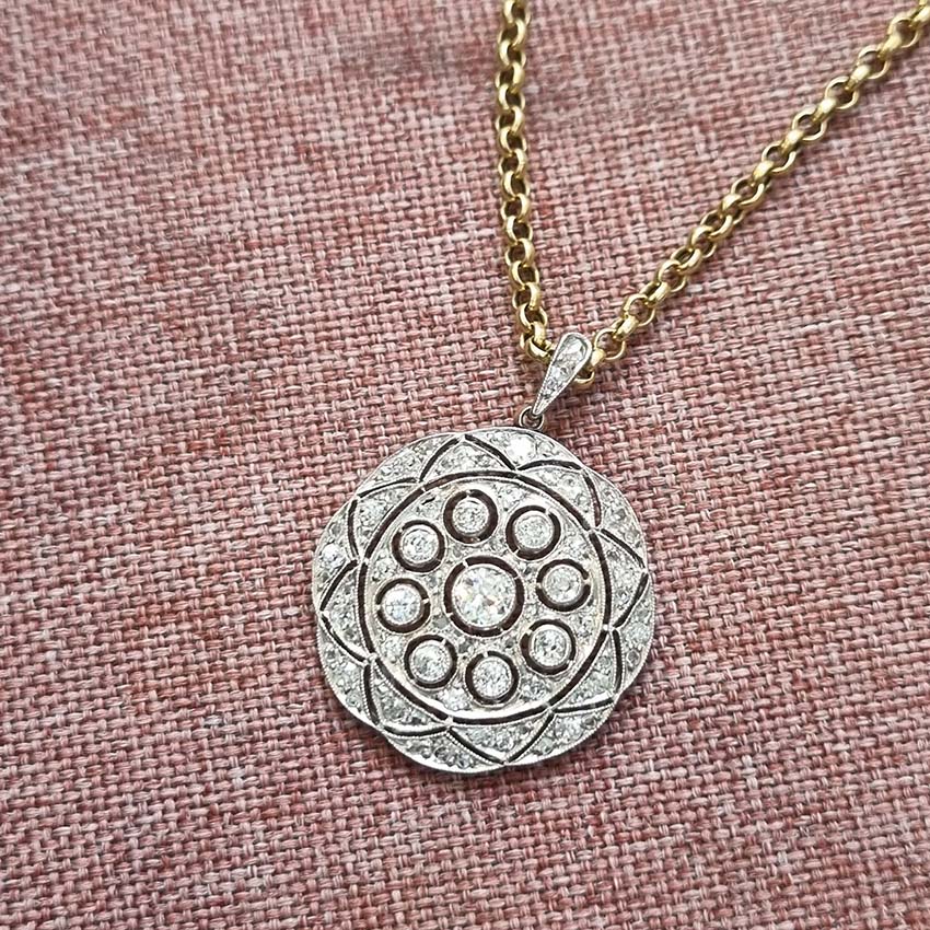 Belle Epoque Antique Old Cut Diamond Circular Pendant, set with 0.90cts sparkling old European transitional cut and rose cut diamonds in openwork platinum. French, Circa 1908