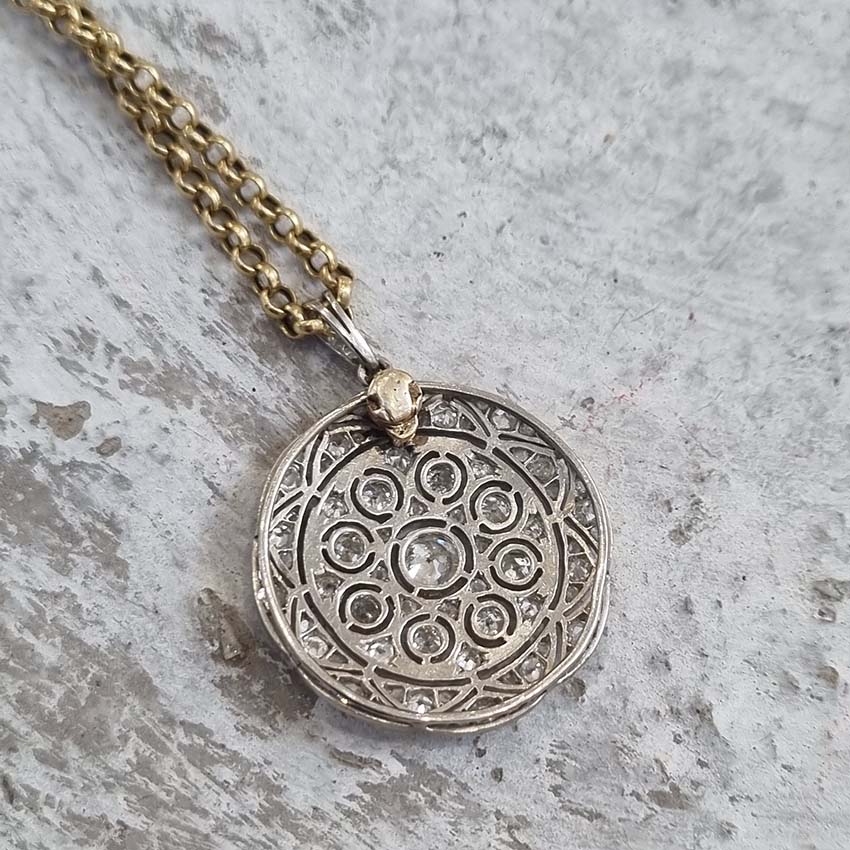 Belle Epoque Antique Old Cut Diamond Circular Pendant, set with 0.90cts sparkling old European transitional cut and rose cut diamonds in openwork platinum. French, Circa 1908