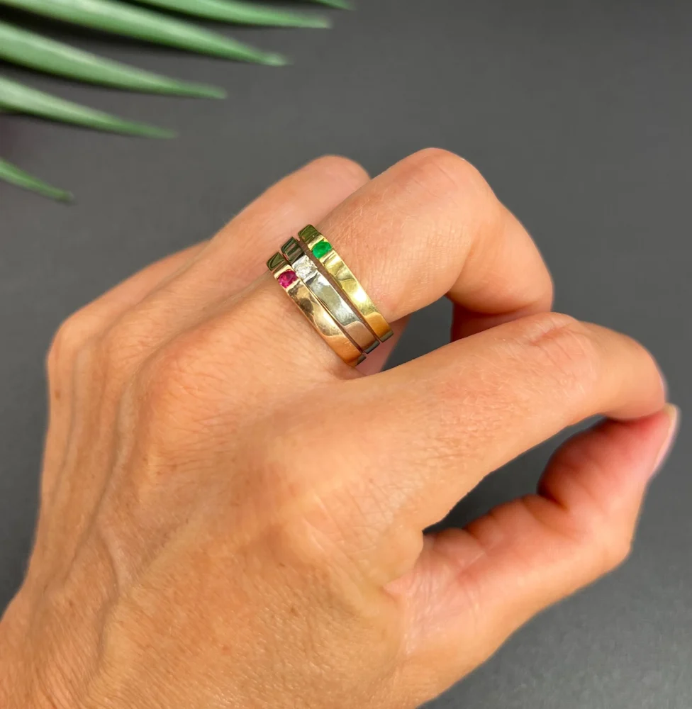 Gold stacking ring with emerald diamond and ruby.