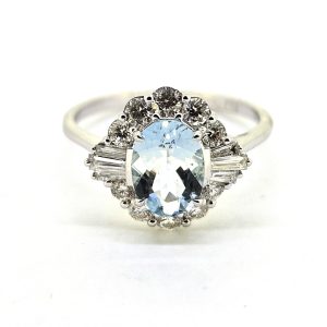 Modern Aquamarine and Diamond Cluster Dress Ring, 0.86ct oval aquamarine surrounded by brilliant-cut diamonds with baguette-cut diamonds to each side in 18ct white gold