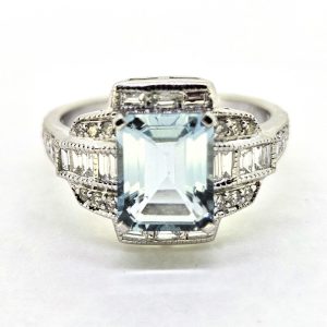 2.11ct Aquamarine and Diamond Cluster Dress Ring, emerald-cut aquamarine surrounded by brilliant and baguette cut diamonds in 18ct white gold
