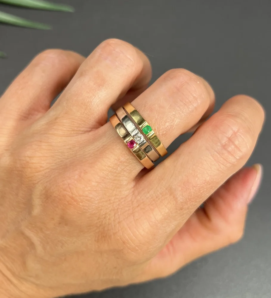 Gold stacking ring with emerald diamond and ruby.